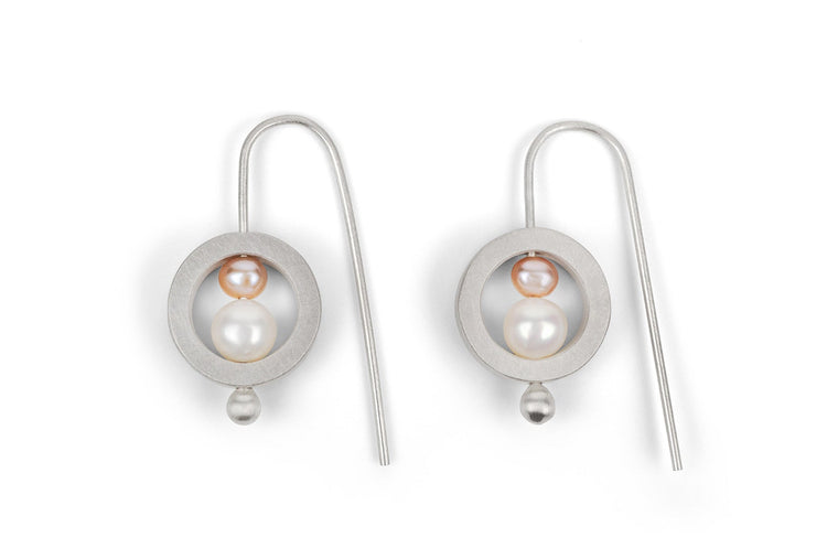 Pair of silver earrings with a central pearl on a white background