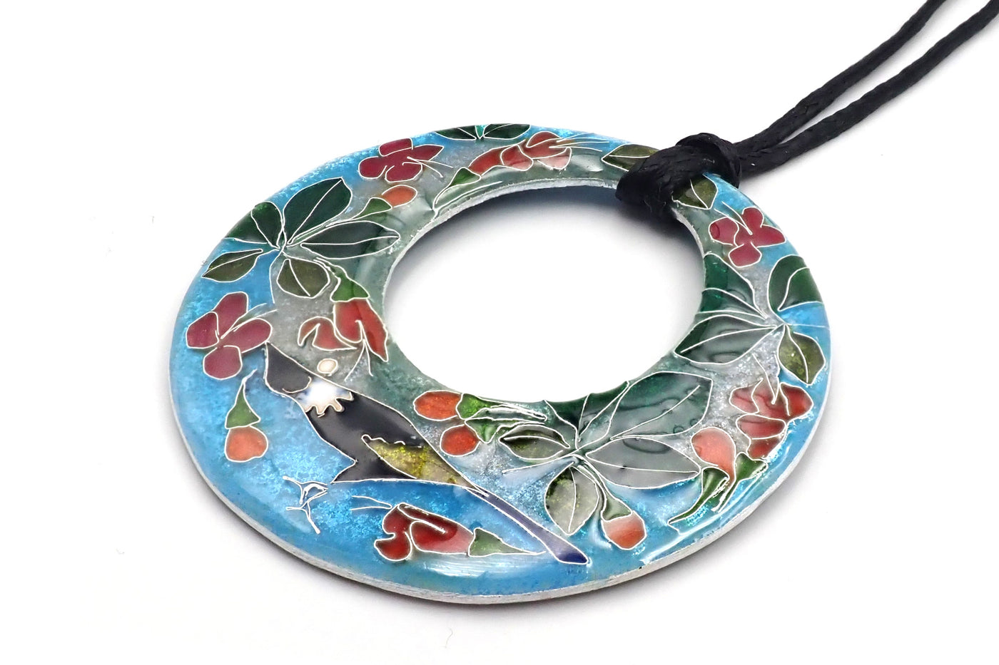 A round silver pendant with a floral pattern, featuring a bird and flowers, on an adjustable black cord.